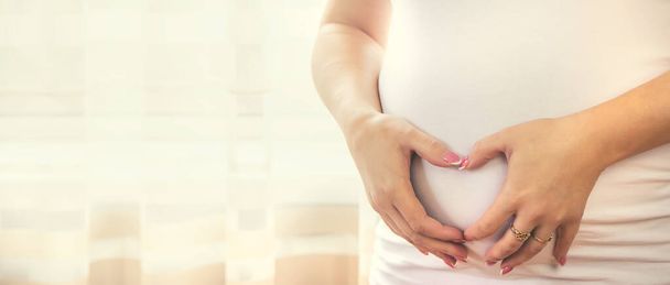 Une femme enceinte se serre le ventre. Concentration sélective. personnes. - Photo, image