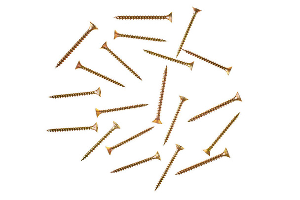 Scattered many glossy metal screws yellow or golden color with spiral thread isolated on white background without shadow. Close-up. Top view - Zdjęcie, obraz