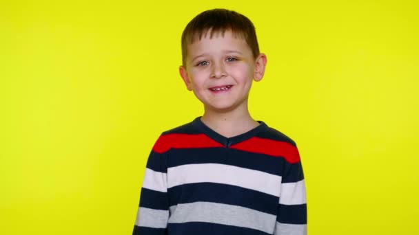Μικρό αγόρι γελάει σε ένα κίτρινο φόντο με αντίγραφο χώρο - Πλάνα, βίντεο