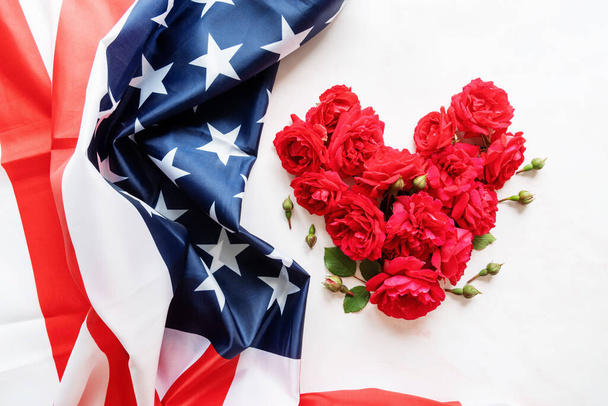 Концепция Дня независимости США. День памяти. Красные розы в форме сердца с плоским флагом США
 - Фото, изображение