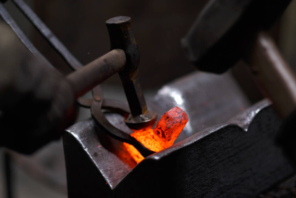 Forging the molten metal, making of an axe, traditional smithy - Photo, Image