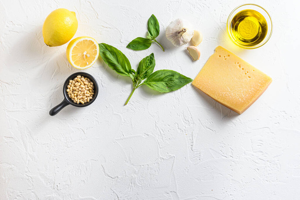 Pesto ingredients Parmesan cheese, basil leaves, pine nuts, olive oil, garlic and salt. Traditional Italian cuisine. white background with a space for a text, view from high angle. - Foto, Imagem