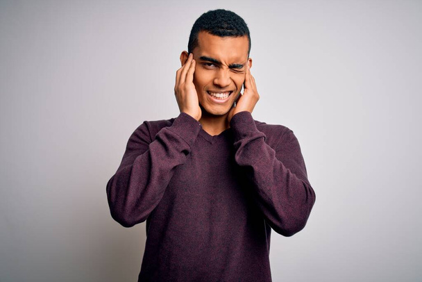Young handsome african american man wearing casual sweater over white background covering ears with fingers with annoyed expression for the noise of loud music. Deaf concept. - Fotografie, Obrázek