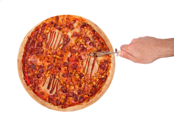 L'homme coupe la pizza italienne barbecue avec jambon, sauce barbecue, bacon et salami, avec un coupe-pizza. Vue de dessus, isolé sur fond blanc
 - Photo, image