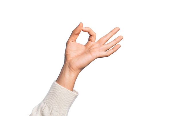 Hand of caucasian young man showing fingers over isolated white background gesturing approval expression doing okay symbol with fingers - Foto, immagini