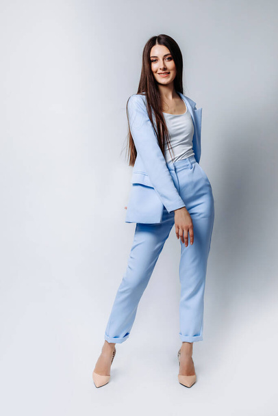 an Indian business woman with a straight hairstyle in a formal blue pantsuit, beige high-heeled shoes. Smiles . full body length isolated on white background - Photo, Image