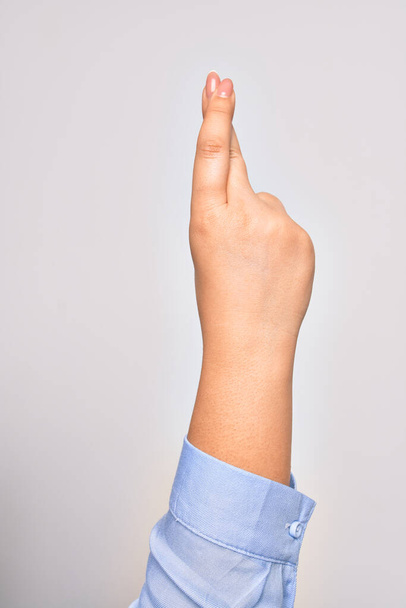 Käsi valkoihoinen nuori nainen tekee onnekas merkki ristissä sormet yli eristetty valkoinen tausta - Valokuva, kuva