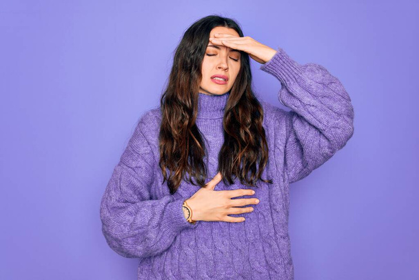 Young beautiful woman wearing casual turtleneck sweater standing over purple background Touching forehead for illness and fever, flu and cold, virus sick - Valokuva, kuva