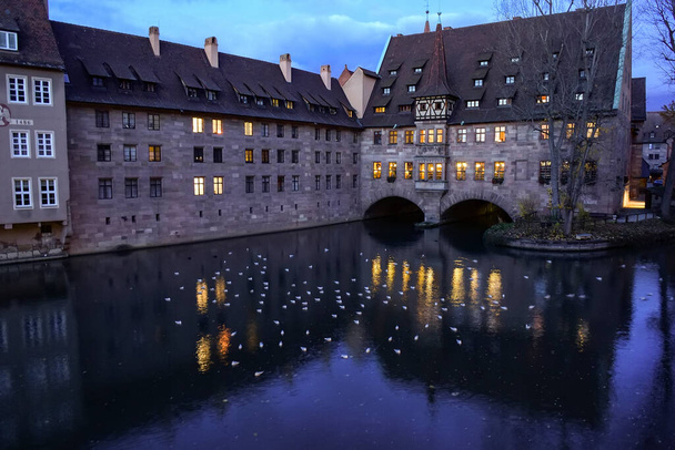 ドイツ・バイエルン州ニュルンベルク旧市街のペグニッツ川沿いにある歴史ある病院「 Heilig-Geist-Capital 」の様子.  - 写真・画像
