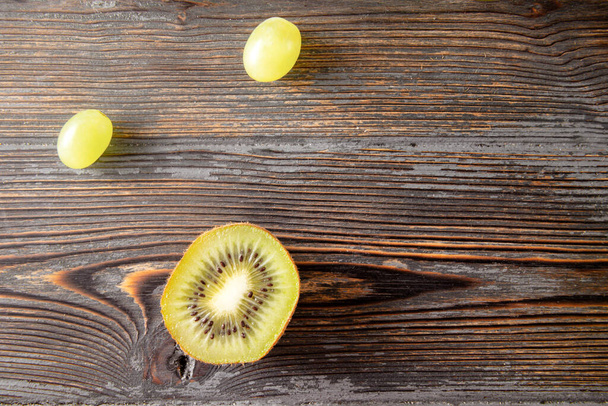 fresh green  grapes, kiwi on a brown wooden background, top view - Photo, Image