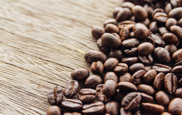 木製の背景にコーヒーの穀物  - 写真・画像
