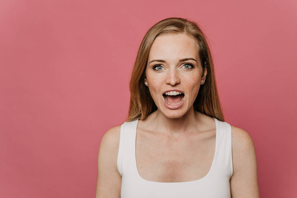 Angry annoyed female gestures with annoyance, screams loudly, expresses irritation, wears white t-shirt, resentful of her boyfriend, isolated over purple studio wall. Stop it please - Foto, Imagen