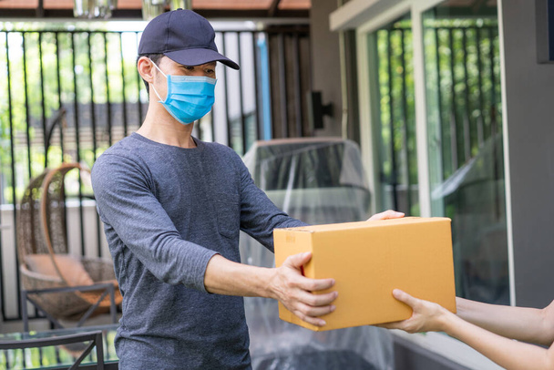 Delivery man wearing protective face mask - Foto, afbeelding