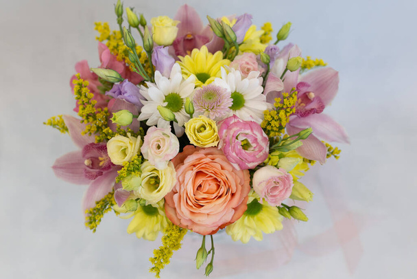 A magnificent bouquet of fresh flowers on a light background (Colors: white, pink, yellow, green. Flowers: rose, eustoma, chrysanthemum, orchid, snapdragon) - Photo, Image