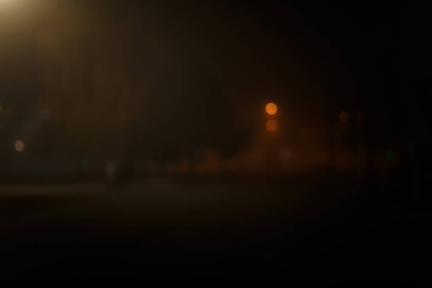 Nieostre ujęcie nocnego miasta z lampami ulicznymi bokeh. - Zdjęcie, obraz
