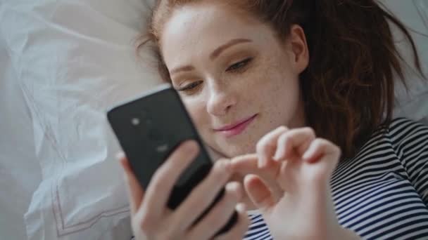 Top view of young woman browsing a phone - Materiał filmowy, wideo