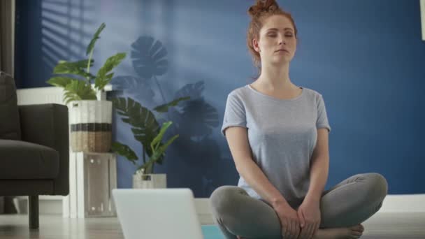 Video de una mujer meditando en casa sobre una esterilla de ejercicio
 - Imágenes, Vídeo