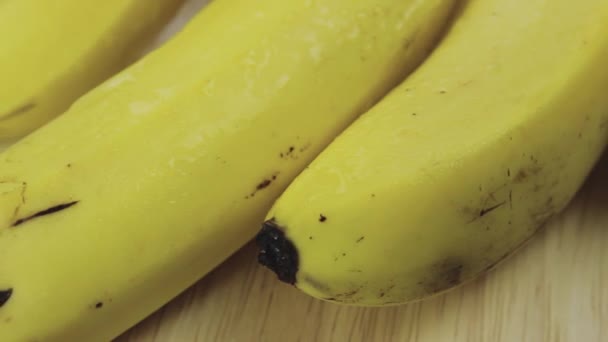 Bunch of fresh yellow bananas on a wooden plate rotates in both directions - Πλάνα, βίντεο
