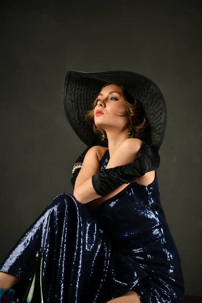krásná žena v modrých večerních šatech v černých rukavicích a černý klobouk - Fotografie, Obrázek