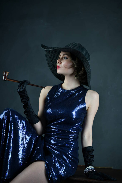 bela mulher em um vestido de noite azul em luvas pretas e um chapéu preto
 - Foto, Imagem