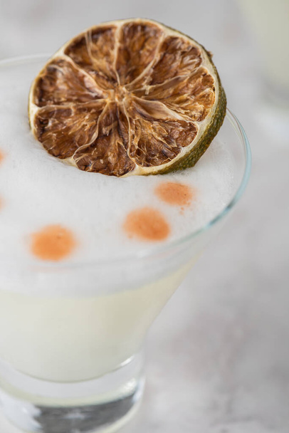 Pisco Sour with dry lime and white foam - Photo, Image