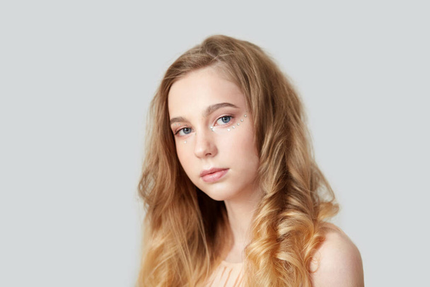 Portrait of a beautiful young girl with bright wavy hair. - Фото, зображення