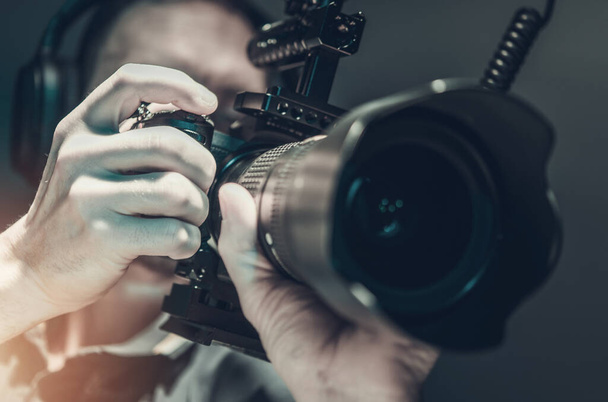 Filmy i przemysł filmowy. kaukascy mężczyźni biorąc wideo wideo ręczne za pomocą lustrzanki aparatu.  - Zdjęcie, obraz