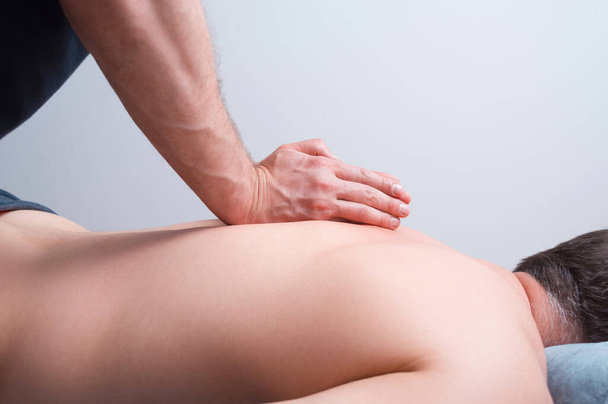 Man making kinesiology massage on white background. - Photo, Image