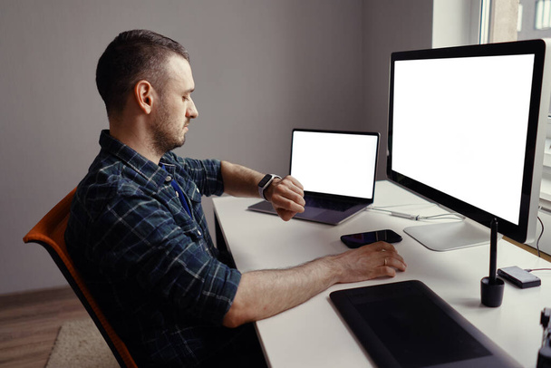 Mann arbeitet zu Hause am Computer mit weißem Bildschirm - Foto, Bild