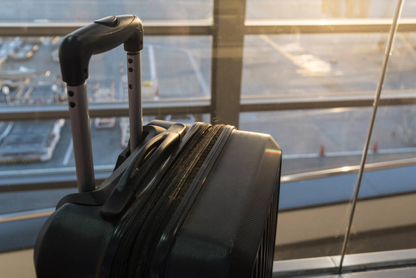 Chiusura di una borsa valigia grande vicino alla finestra dell'aeroporto. Concetto di viaggio
 - Foto, immagini