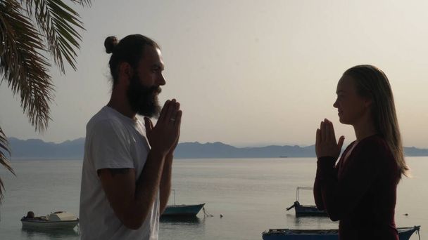 Yoga öğretmeni deniz kenarındaki bir yerde öğrenciyle el ele verdi.. - Fotoğraf, Görsel