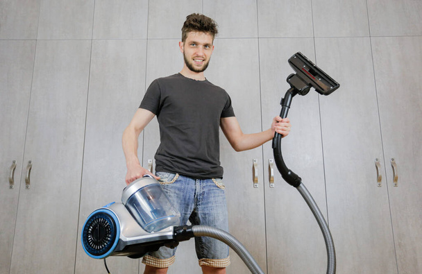Καθαρισμός σπιτιού. Άνθρωπος με ηλεκτρική σκούπα - Φωτογραφία, εικόνα