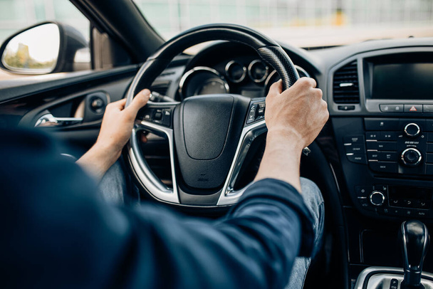 Primer plano de la mano de un hombre sosteniendo el volante mientras conduce un coche
 - Foto, imagen