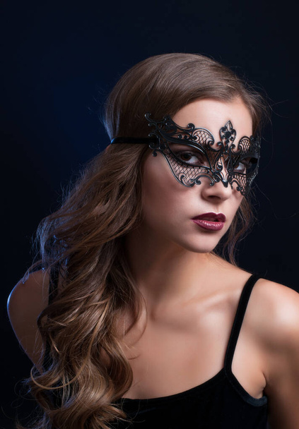 young pretty brunette woman in venetian lacy mask. close up portrait lacy mask. red lips make up. erotic passion woman image on black background - Photo, Image