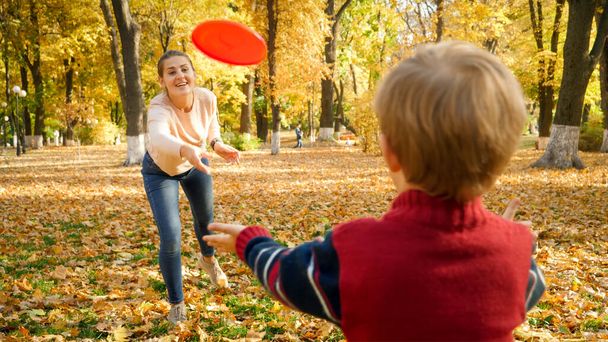 かわいいです男の子遊びますフリスビーで彼の母親とともに秋の公園 - 写真・画像