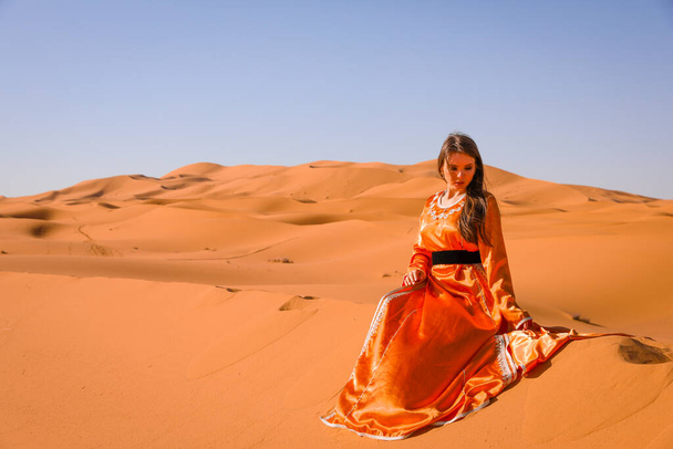 Чудова дівчина в марокканському вбранні в пустелі Сахара.. - Фото, зображення