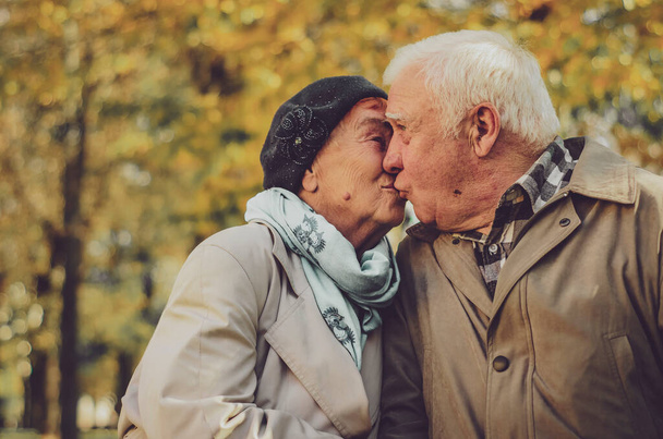 Love lives forever! Senior couple at home. Handsome old man and attractive old woman are hugging, kissing and enjoying spending time together. - Foto, immagini