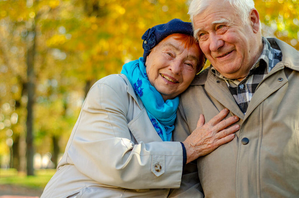 Love lives forever! Senior couple at outdoors. Very old man and attractive old woman are hugging and enjoying spending time together. - Fotó, kép