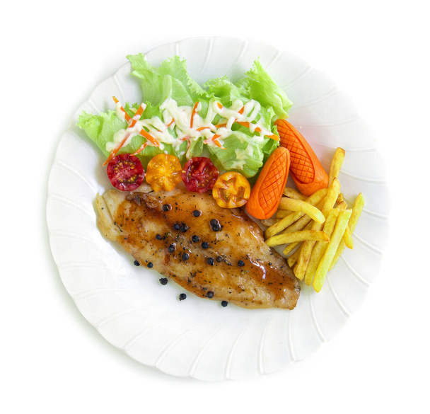 Poisson grillé Pangasius Filet steak avec sauce barbecue surmonté de poivrons noirs et salade décorer frenchfrites et tomate sculpté style vue dessus
 - Photo, image