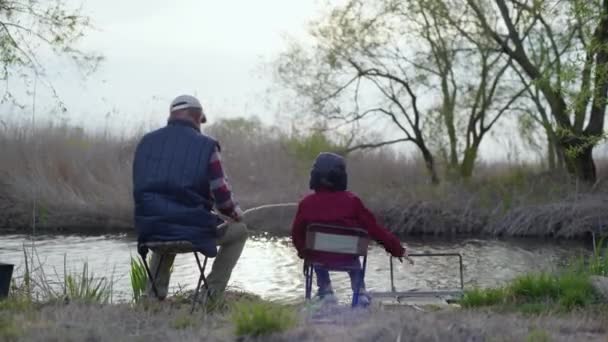 vanha kalastaja yhdessä hänen onnellinen pojanpoikansa saalis kalaa käyttäen onki joella
 - Materiaali, video