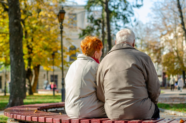 Romantic senior mature couple is sitting in the park in fall - Foto, Imagem