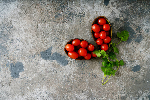 Ντομάτες κεράσι σε δέρμα αβοκάντο διακοσμημένες με μαϊντανό. Άνω όψη - Φωτογραφία, εικόνα