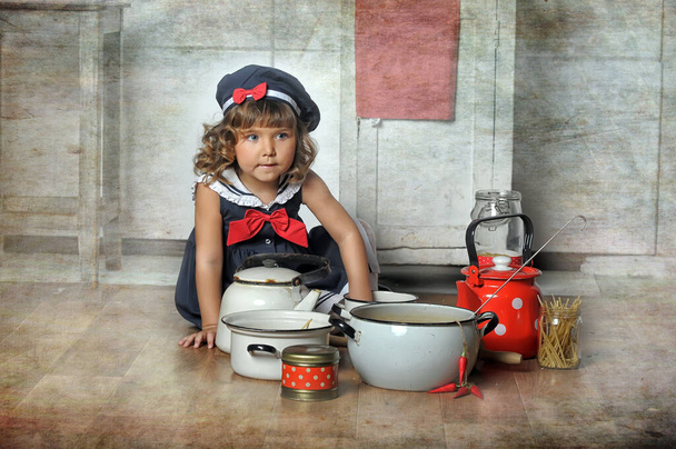 little brunette girl with curls in a marine suit - dress and hat in the kitchen - Fotó, kép