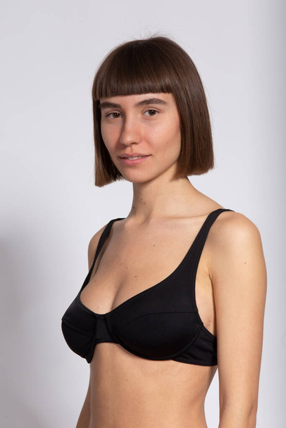 3/4 portrait of sweet girl in black bra and short hairstyle isolated on white, model polaroids - Photo, Image