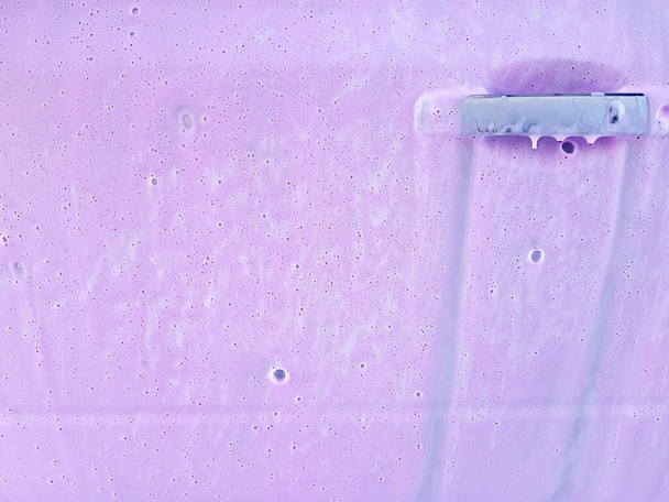 πόρτα οδηγού αυτοκινήτου με λαβή που καλύπτεται ενεργό αφρό για το πλύσιμο ενός βρώμικου αυτοκινήτου και ροζ κερί, closeup της διαδικασίας της φροντίδας του σώματος του αυτοκινήτου με αντίγραφο χώρο. - Φωτογραφία, εικόνα