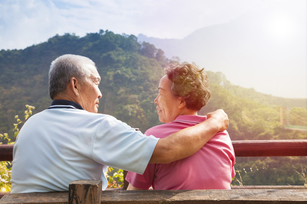 Seniorenpaar sitzt auf Bank im Naturpark - Foto, Bild