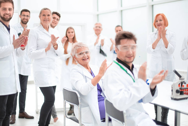 Группа молодых ученых поздравляет коллегу с аплодисментами
 - Фото, изображение
