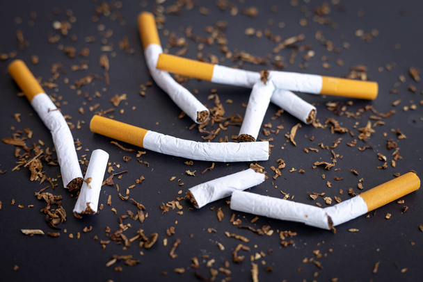 Gebroken sigaretten op zwarte achtergrond, World No Tobacco Day concept. - Foto, afbeelding