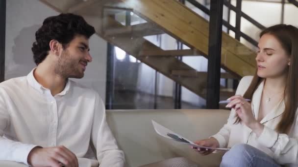 Νέοι επιχειρηματίες συζητούν την οικονομική κατάσταση της εταιρείας, ενώ κάθονται στον καναπέ - Πλάνα, βίντεο