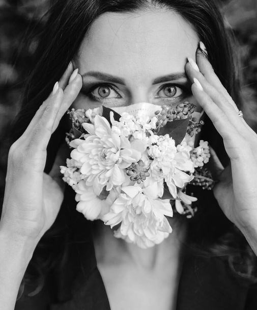 Retrato de mujer hermosa en máscara protectora con flores
. - Foto, imagen